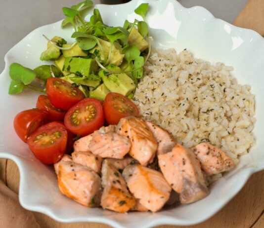 건강한 식단, 행복한 삶의 첫걸음 a white bowl filled with chicken, rice, tomatoes and avocado