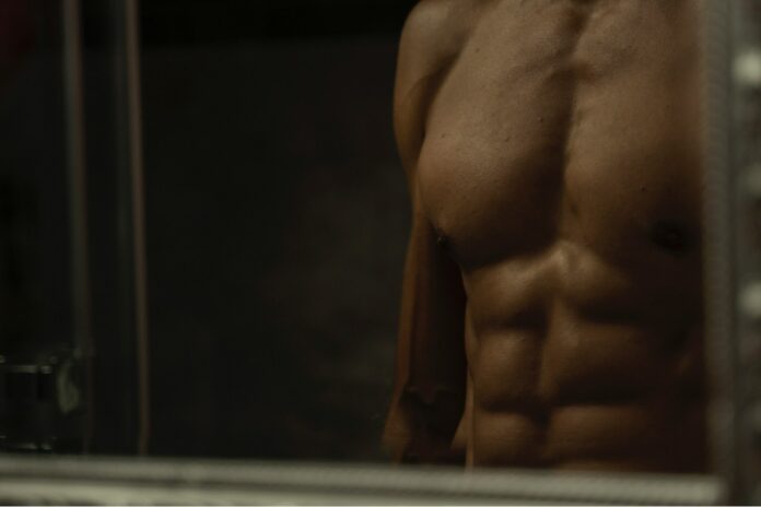 Photo by Andre Taissin topless man in black shorts