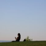 스트레스, 일상 속 작은 변화로 관리한다… 실천 가능한 최신 루틴은? a woman sitting on top of a lush green hillside