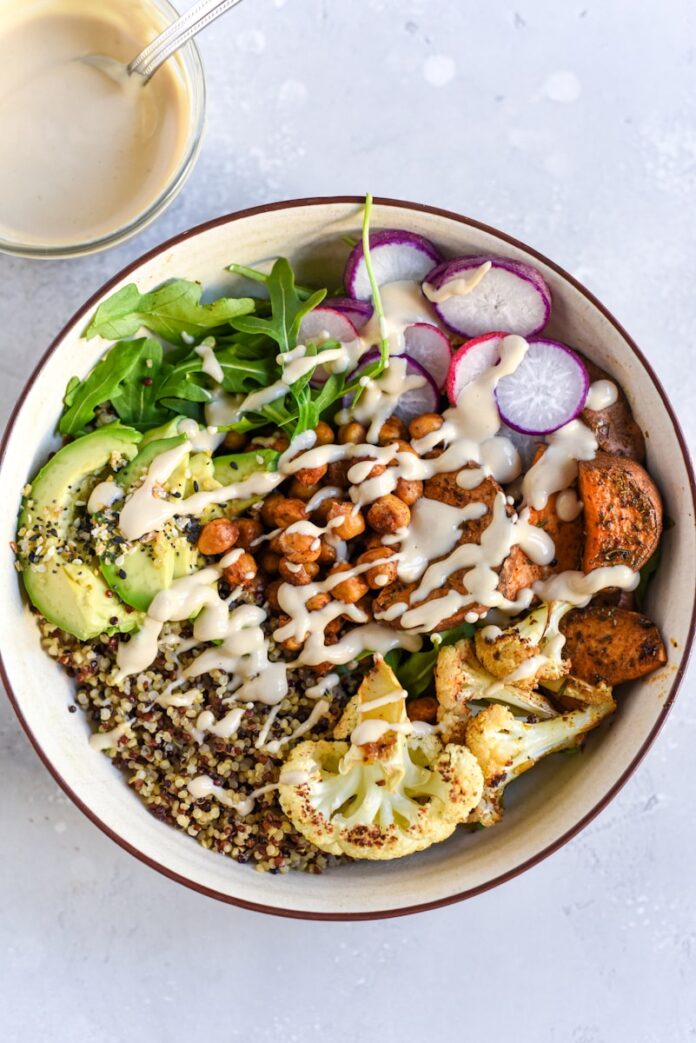 Photo by Caroline Green a bowl filled with vegetables and dressing next to a glass of milk