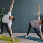 남자와 요가(Men’s Yoga): “유연해야 할 수 있다?” 편견을 깨고 남성이 요가 매트에 서야 하는 이유 Couple practicing yoga in a modern room.