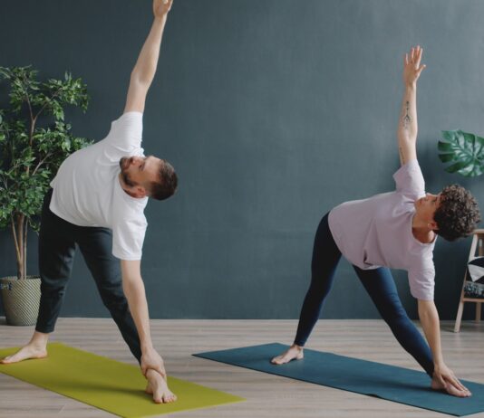 남자와 요가(Men’s Yoga): “유연해야 할 수 있다?” 편견을 깨고 남성이 요가 매트에 서야 하는 이유 Couple practicing yoga in a modern room.